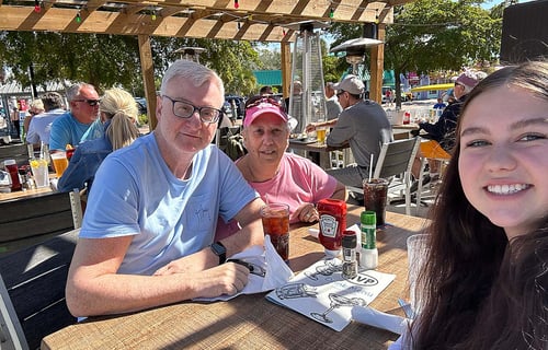Schülerin mit ihrer Gastfamilie draußen in einem Restaurant