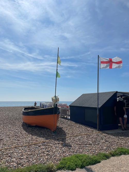 Boot am Strand und Haus mit Englandflagge