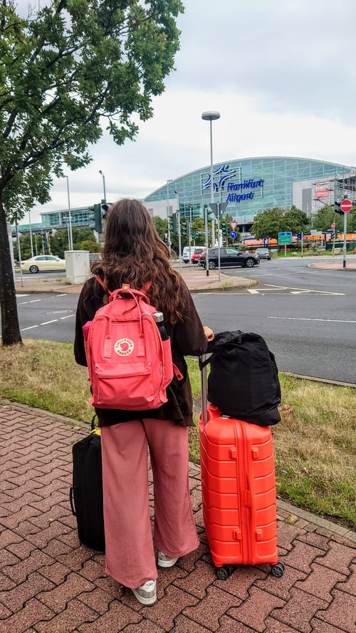 Mädchen mit Koffern und auf die Straße schauend