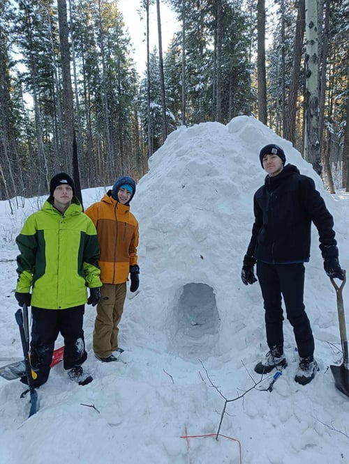 Drei Jungs mit Schaufeln vor einem Iglu