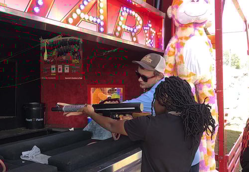 Ein Mädchen bei einem Stand auf dem Rummel