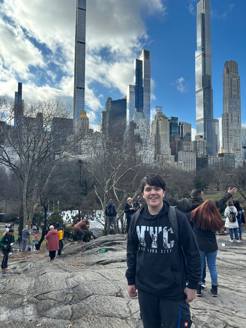 Junge in einem Park vor hohen Gebäuden