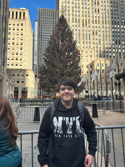 Ein Junge steht vor einem Weihnachtsbaum