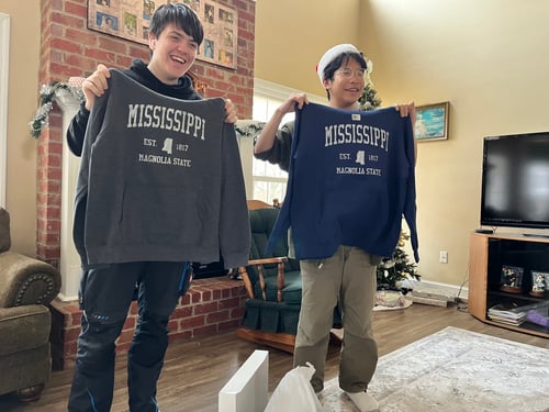 Zwei Jungs halten Hoodies hoch