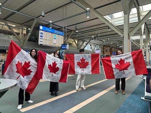 Vier Jugendliche halten Kanada Flaggen hoch