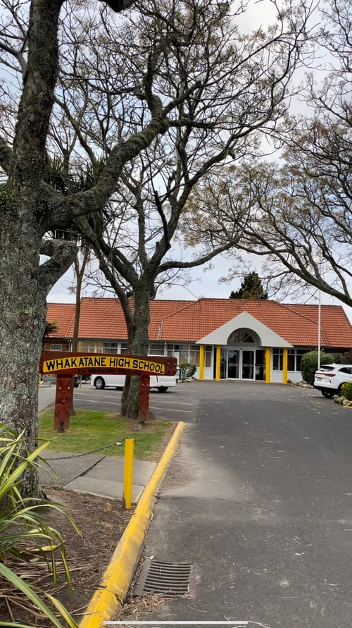 Schulgebäude und Bäume auf der linken Seite der Straße