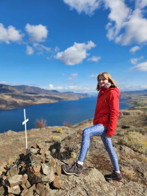 Mädchen auf einem Stein in den Bergen