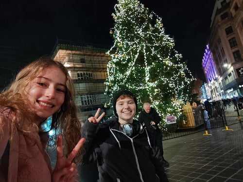 Zwei Jugendliche vor einem geschmückten Weihnachtsbaum