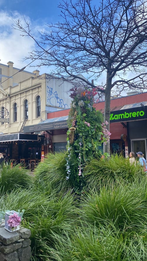 Grüne Statue und Wiese vor einem Gebäude