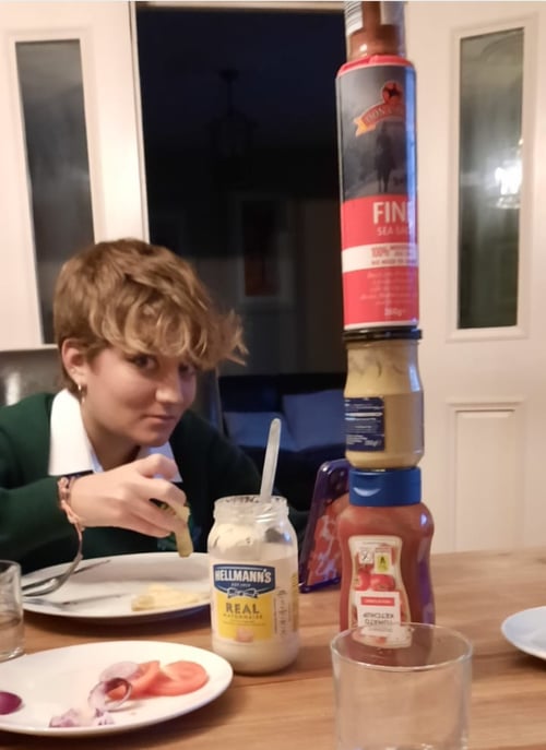 Ein Mädchen und daneben auf dem Tisch ein Stapel an Soßen