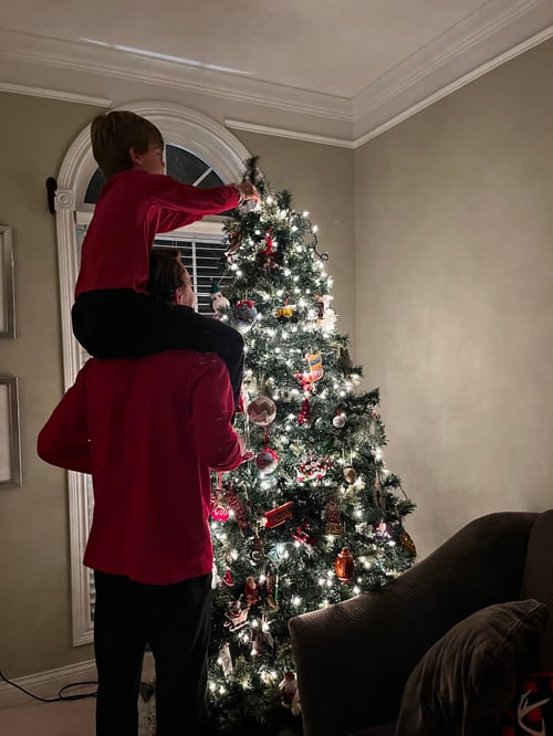 Zwei Kinder schmücken einen Weihnachtsbaum