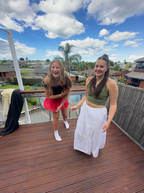 Zwei lachende Mädchen auf einem Balkon