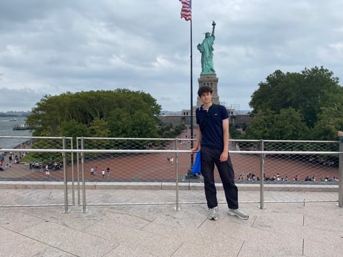 Ein Junge posiert vor einer Statue