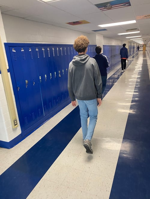 Eine Schulhalle mit blauen Spinden und Schülern