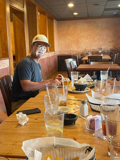 Ein Junge mit Kuchen im Gesicht an einem Tisch