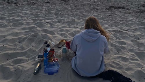 Ein Mädchen sitzend am Strand