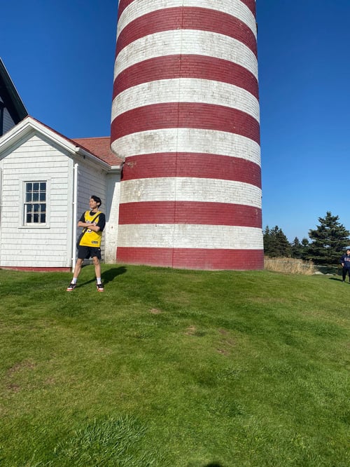Ein Junge vor einem weiß rot gestreiften Turm