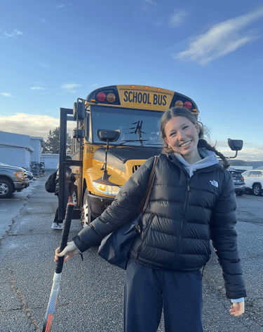 Schülerin vor einem gelben Schulbus in Kanada
