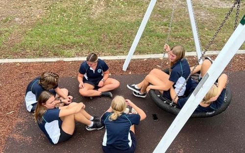 Schülerinnen auf dem Schulplatz mit einer Schaukel