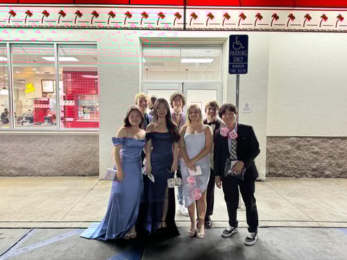 Jugendliche in Kleidern und Anzug