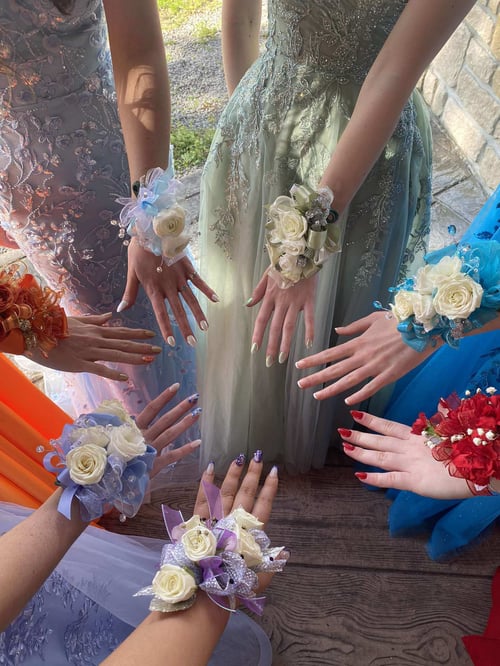 Hände mit Blumen und gemachten Nägeln