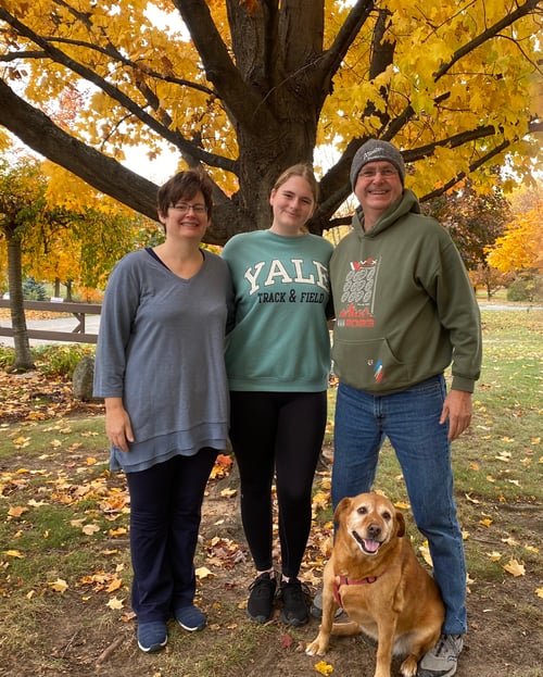 Familie mit Hund unter einem Baum