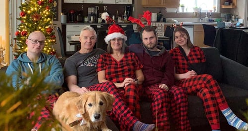 Familie in Weihnachtskleidung und Hund