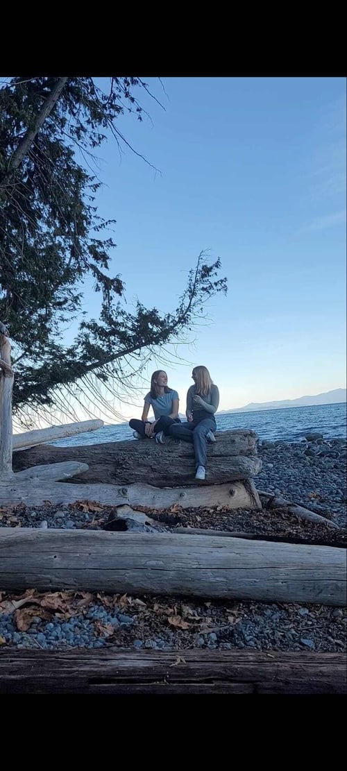 Zwei Mädchen auf einem Baumstamm