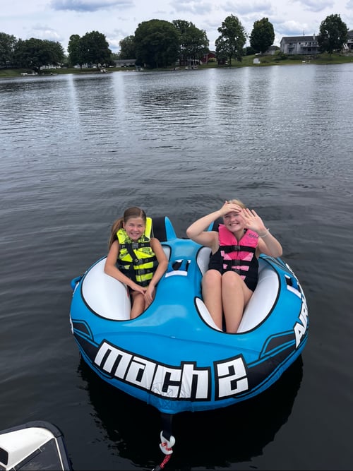 Zwei Mädchen auf einem aufblasbarem Boot auf dem Wasser