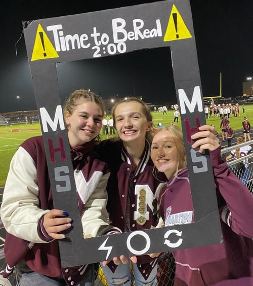 Drei Schülerinnen vor dem Footballfeld