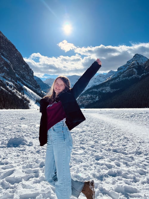 Ein Mädchen mit Schnee und Bergen im Hintergrund