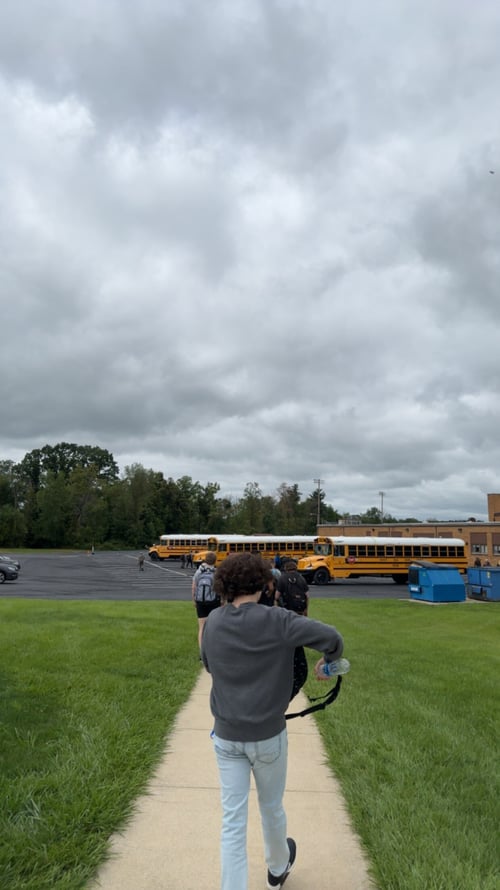 Ein Junge vor einem gelben Schulbus