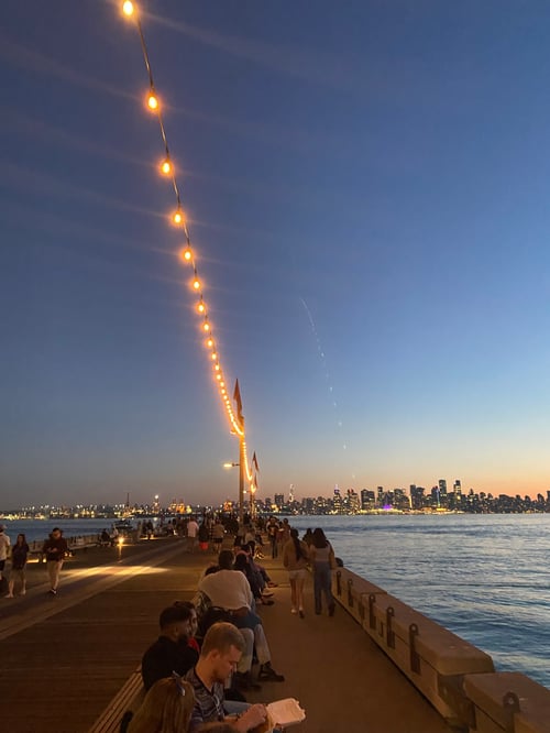 Auf der Brücke bei Sonnenuntergang mit Wasser und Stadt im Hintergrund