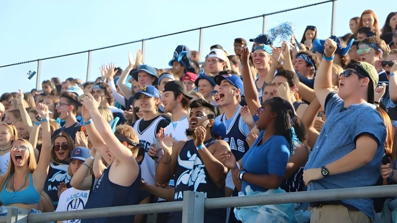 Eine große Gruppe von Personen versammelt sich im Freien auf dem Gelände der A.B. Lucas Secondary School.