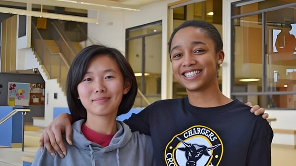 Zwei Frauen stehen zusammen in einem Innenraum auf dem Campus der Abbey Park High School.