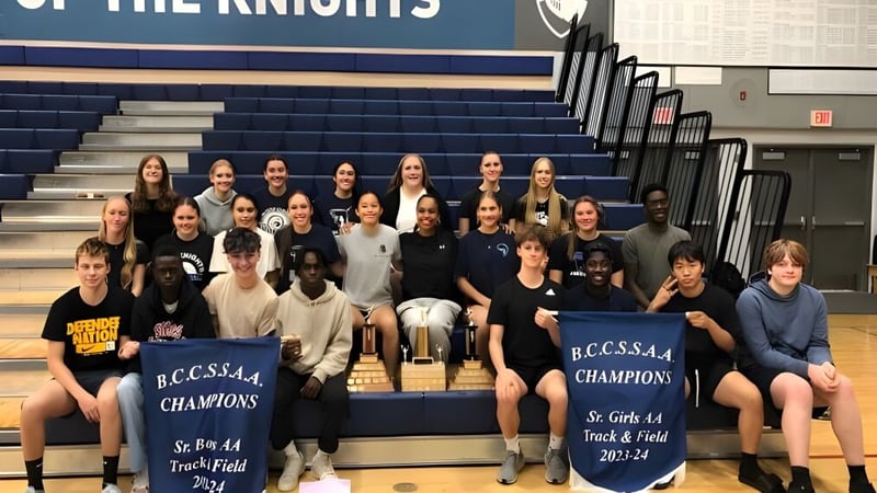 Eine Gruppe von Schülern der Abbotsford Christian School posiert in der Turnhalle vor Bannern des Sportvereins.