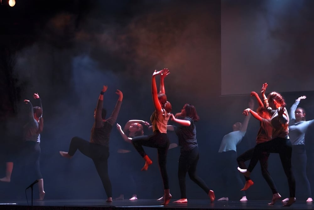 Schüler der Abbotsford School of Integrated Arts führen eine Tanzaufführung auf einer dunkel beleuchteten Bühne mit Nebel durch.