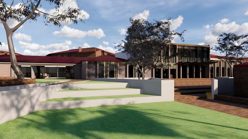 Das moderne mehrstöckige Gebäude der Aberfoyle Park High School mit rotem Dach und Glasfront ist von Grünflächen und Bäumen umgeben.