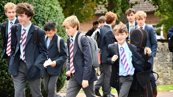 Eine Gruppe Schüler der Abingdon School geht gemeinsam auf einem von grünen Pflanzen umgebenen Weg.