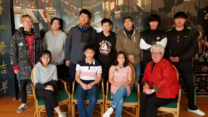 Eine Gruppe von Schülerinnen und Schülern steht gemeinsam in einem dekorativen Raum auf dem Campus der Accelerated School.