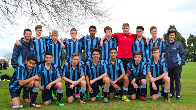 Eine Gruppe von jungen Fußballspielerinnen posiert auf dem Spielfeld der ACG Strathallan.
