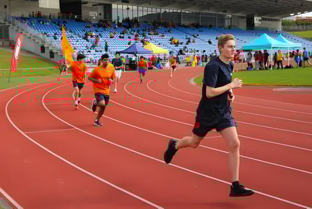 Athleten laufen auf der Laufbahn vor dem Stadion auf dem Campus der ACG Sunderland.