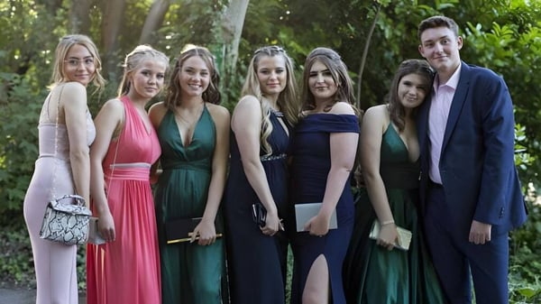 Eine Gruppe gut gekleideter Personen steht gemeinsam in einer grünen Außenanlage der Ackworth School.