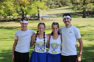 Eine Gruppe von vier Personen steht gemeinsam in einem Park auf dem Gelände der Acorn High School.