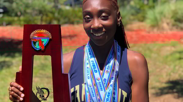 Eine Person in traditioneller afrikanischer Kleidung steht im Grünen auf dem Gelände der Admiral Farragut Academy.