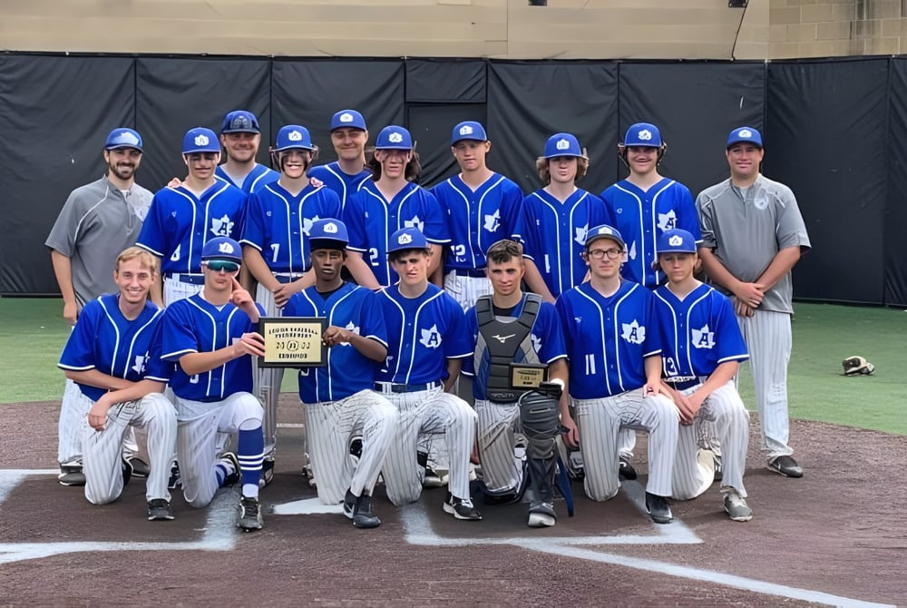Eine Gruppe von Baseballspielern in blauen und weißen Uniformen steht auf dem Baseballfeld der Adrian High School.