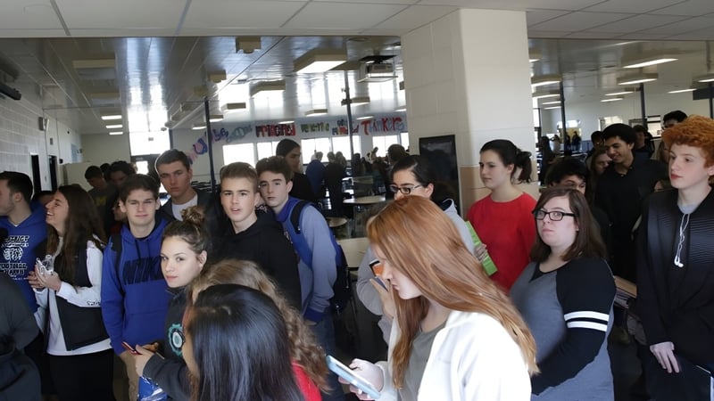 Schüler der Adrian High School füllen einen belebten Flur mit Plakaten an den Wänden.
