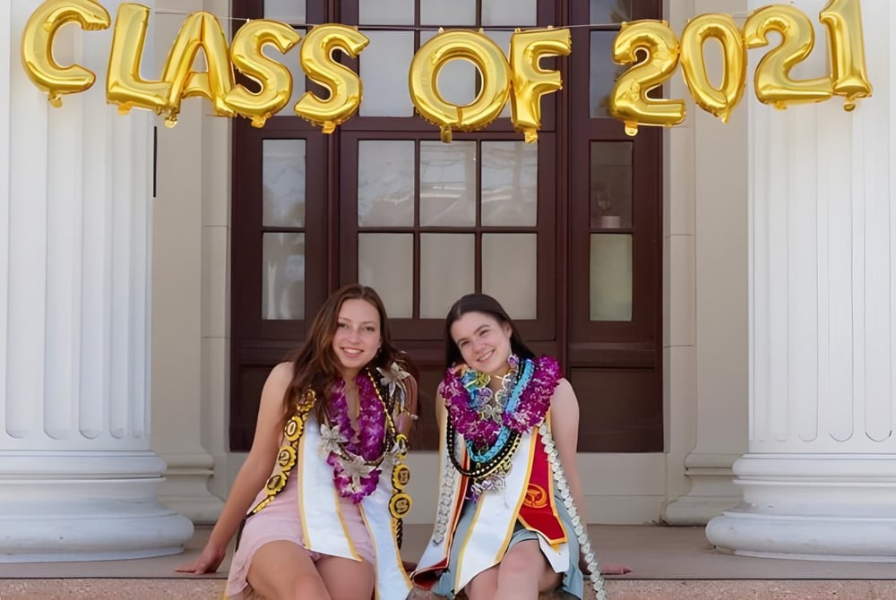 Zwei Schülerinnen der Alameda High School stehen vor einer Tür mit 'Class of 2021' Luftballons.