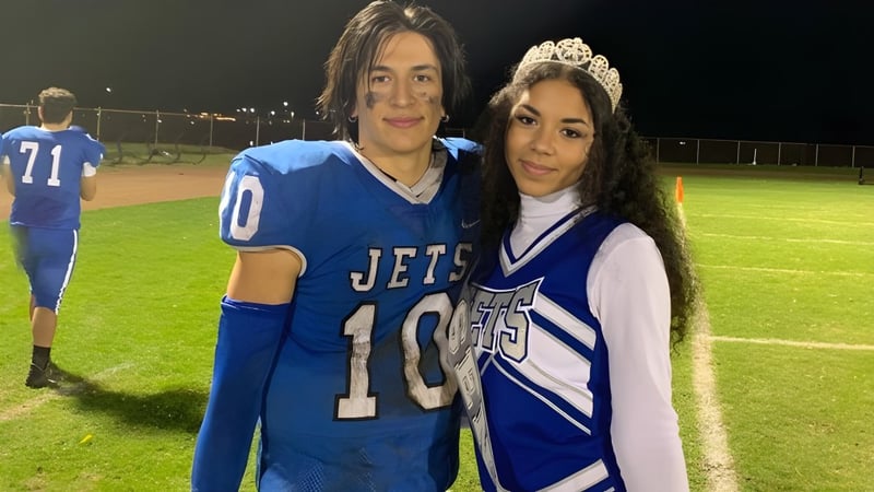 Zwei Schülerinnen und Schüler stehen auf dem Sportfeld des Alameda Unified School District bei Nacht.