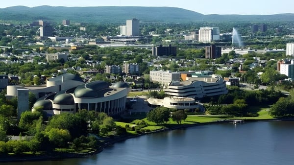 Blick auf die moderne Skyline einer Stadt mit Wasser und grünen Hügeln im Hintergrund nahe der Alberni District Secondary School.
